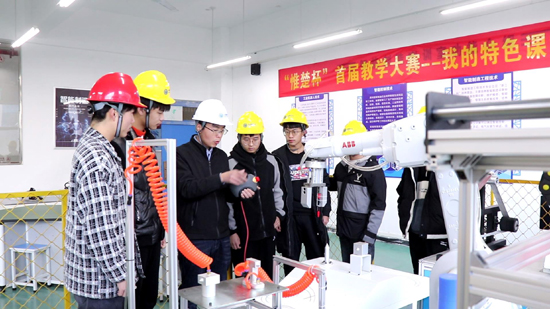 王建华老师指导学生操作机器人.jpg